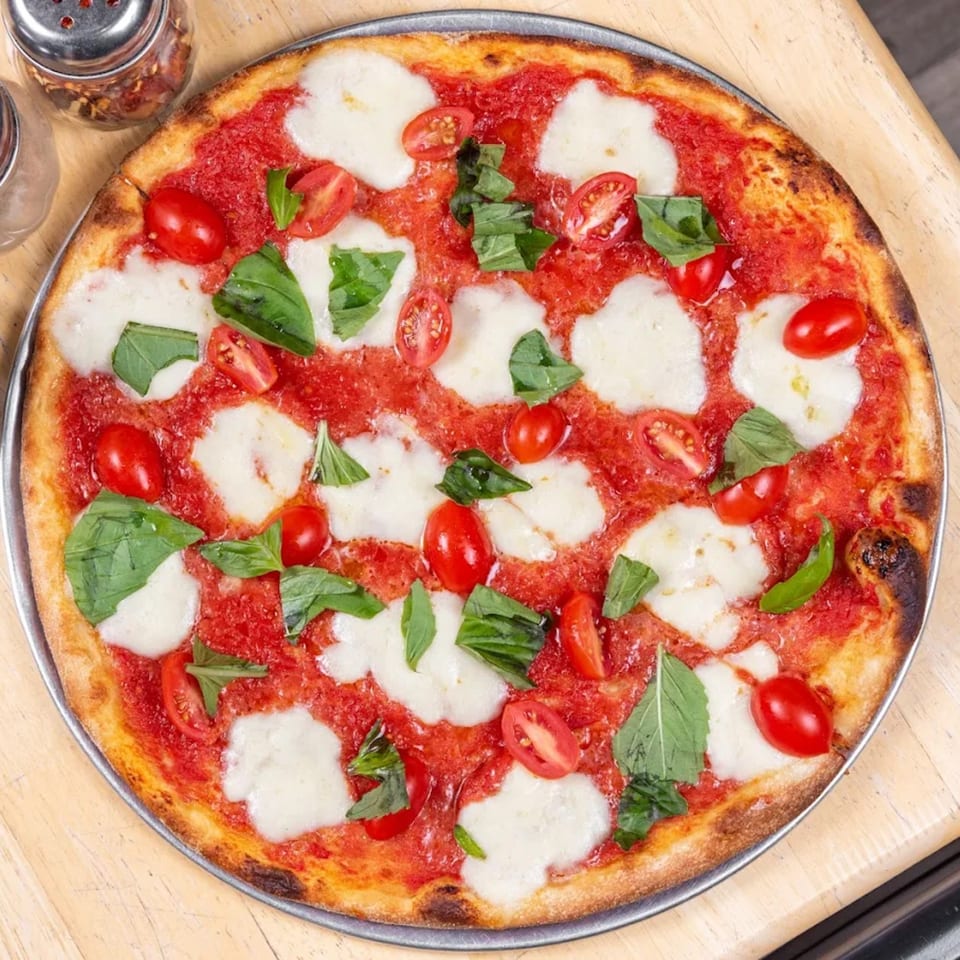 A L'arte Della Pizza Brooklyn Margherita pizza with fresh mozzarella, basil, and cherry tomatoes.