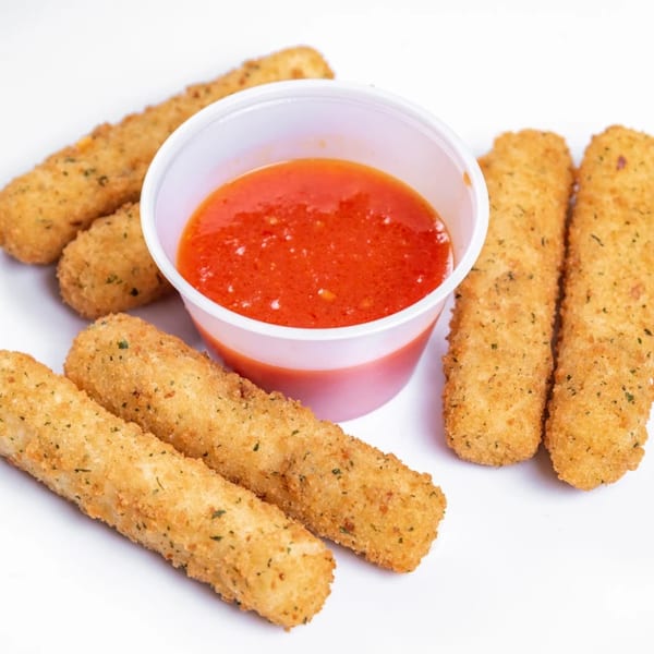 Golden-brown mozzarella sticks with herbs, arranged around a white cup of red marinara sauce.